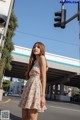 A woman standing in the middle of a street next to a traffic light.