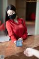 A woman wearing a face mask sitting at a table.