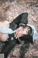 A woman laying on the ground with her head in her hands.