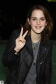 A woman in a black leather jacket holding up a peace sign.