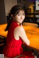 A woman in a red dress sitting at a table.