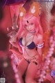 A woman with pink hair wearing a bikini and cat ears.