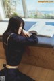 A woman sitting on a bench reading a book.