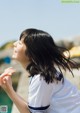 A woman in a white shirt and blue and white striped shirt.